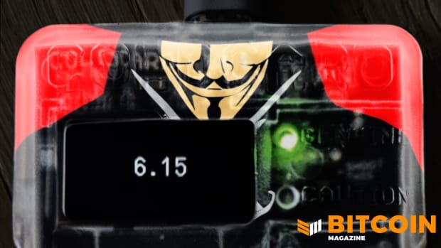 A Cold Card bitcoin hardware wallet, with a picture of Satoshi rendered as Guy Fawkes, and 6.15 BTC on it top photo.