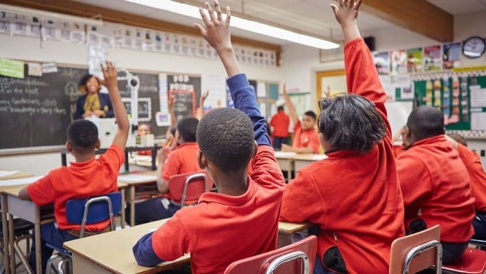 Teachers in the classroom raise their hands