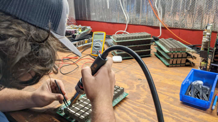 Nick Sears repairs hardware at the SCATE Ventures Inc. mining farm in Dallesport, Washington. Source