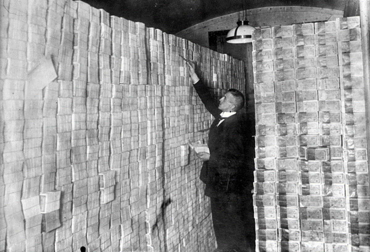 Man stacking money in the Berlin bank, 1922 (Source)