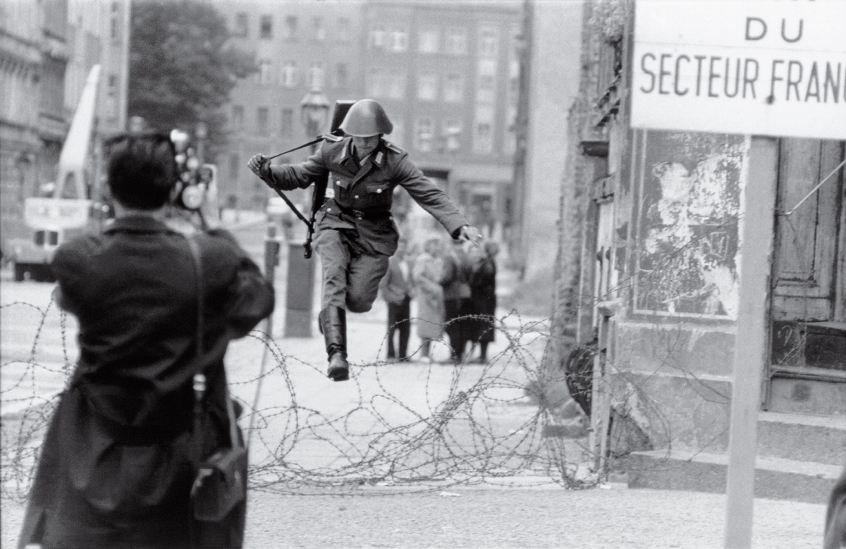 An East German border guard jumping to West Berlin — the “Leap of Freedom” — with only the clothes on his back.